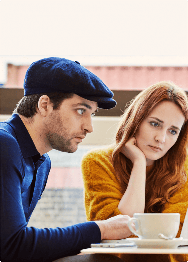Un homme et une femme prenant un café et travaillant ensemble sur un ordinateur portable