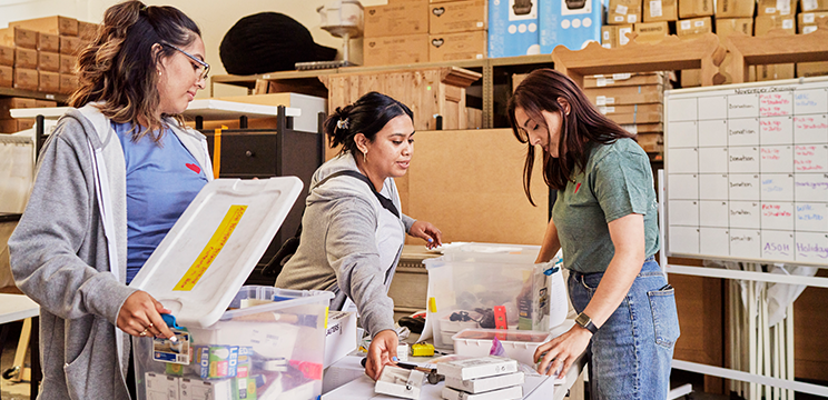 A group of volunteers packs materials together around a table.