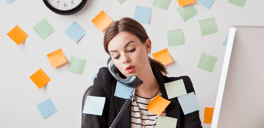 Busy woman on the phone surrounded by sticky notes
