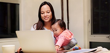 Woman working from home holding baby