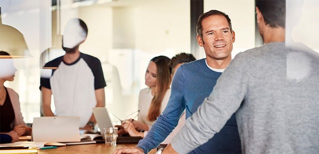Afbeelding van twee professionals in gesprek