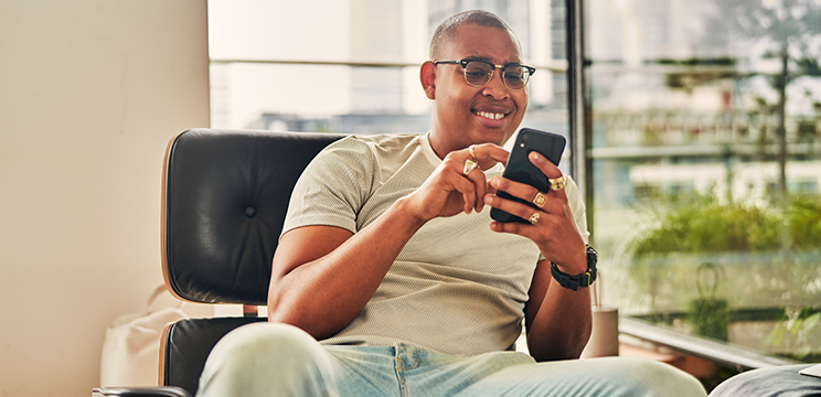 Man smiling at his phone in an office