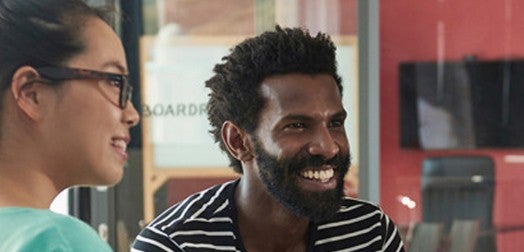 Imagem de duas pessoas sorrindo.