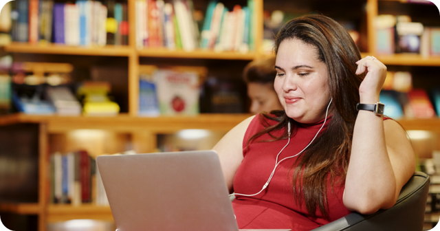 Woman working on laptop in cozy library